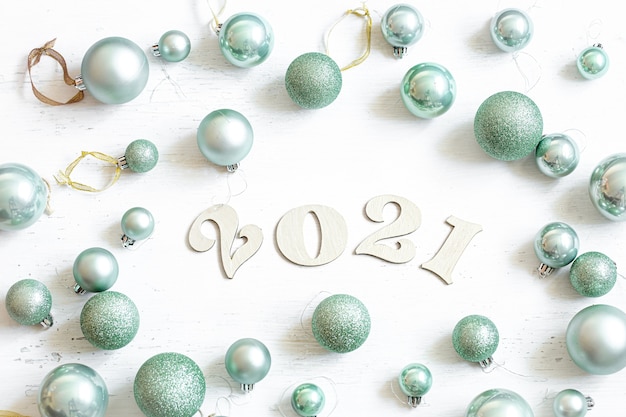 Composición de año nuevo con número de madera para el próximo año y bolas de navidad azules aisladas.