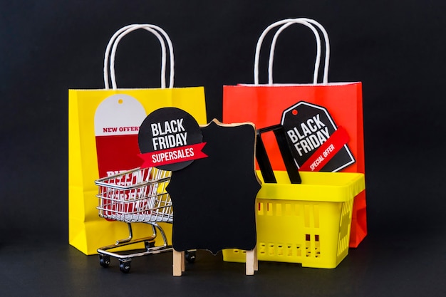 Foto gratuita composición de black friday con bolsas, cesta y tabla