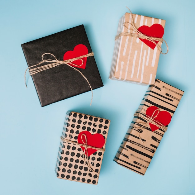 Foto gratuita composición de las cajas presentes en papeles de cariño con corazones de papel decorativo.