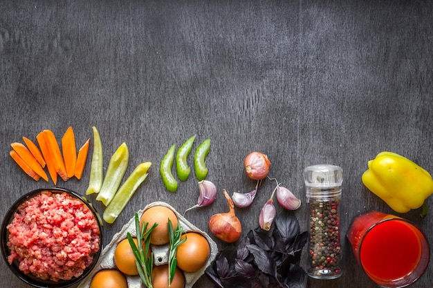 Composición de carne cruda con verduras y especias sobre fondo de madera