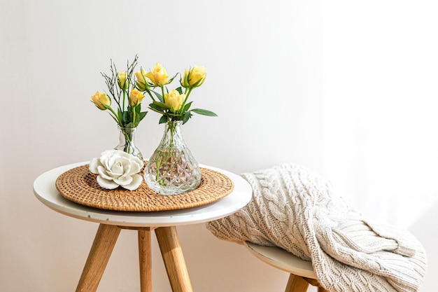 Composición casera con flores en un jarrón en el interior de una habitación blanca.