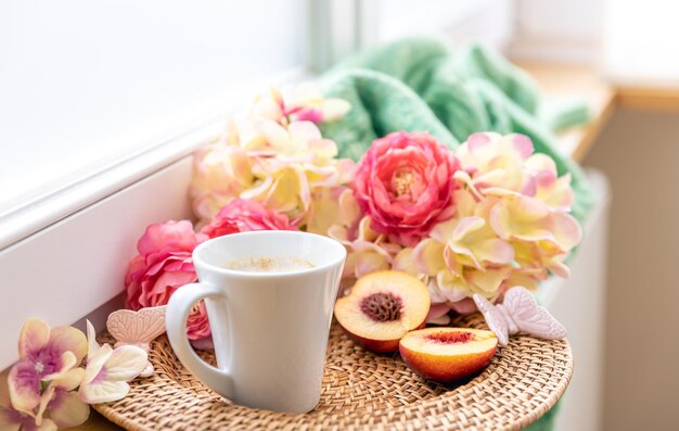 Composición casera con una taza de flores de café y un elemento de punto.