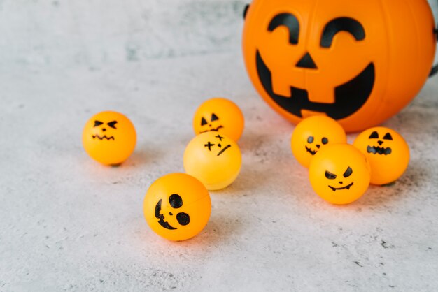 Composición con cesta de calabaza de Halloween y pequeñas bolas naranjas