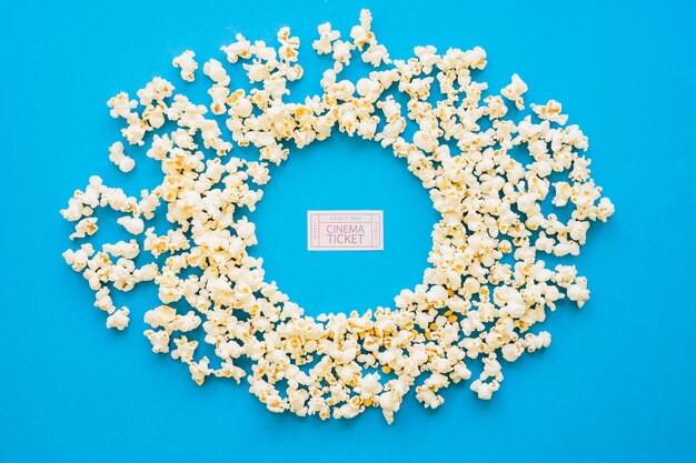 Composición circular de palomitas con entrada de cine