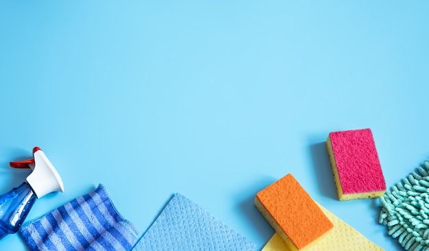 Composición colorida con esponjas, trapos, guantes y detergente para limpieza general. Endecha plana