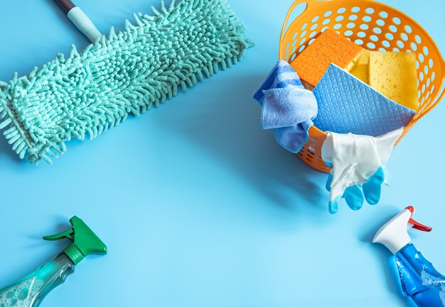 Composición colorida con fregona, esponjas, trapos, guantes y detergentes para limpieza general. Fondo de concepto de servicio de limpieza