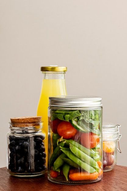 Composición con comida envasada y botella de jugo.