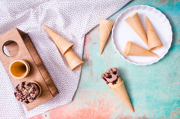 Composición de copas de obleas vacías y helado en conos de waffle