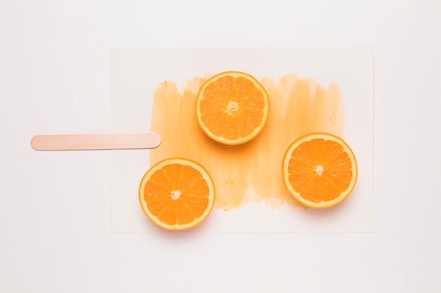Composición creativa de paletas de naranja en rodajas en el palo