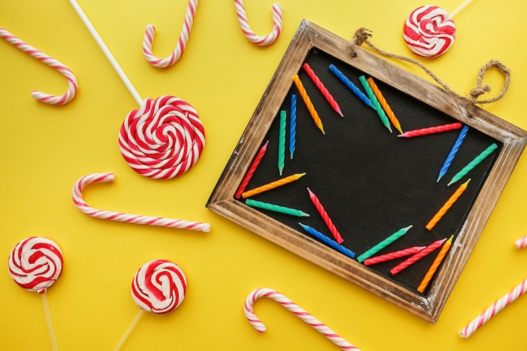 Foto gratuito composición de cumpleaños con dulces y pizarra