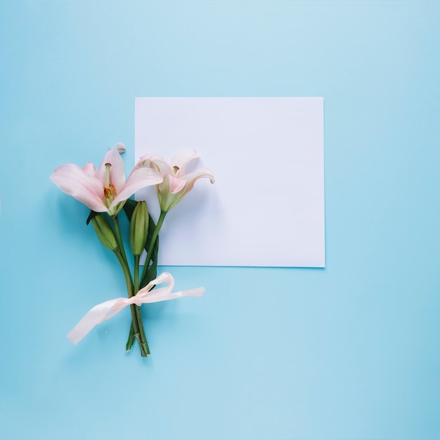 Composición del día de la madre con flores y papel blanco