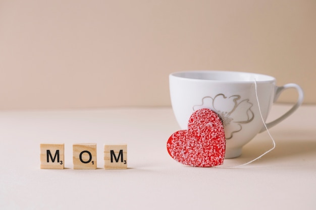 Composición del día de la madre con taza y corazón dulce