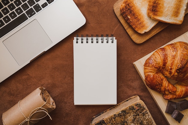 Composición del día del padre con cuaderno en blanco, tostadas y croissant