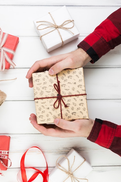 Composición para el día del padre con manos sujetando caja de regalo