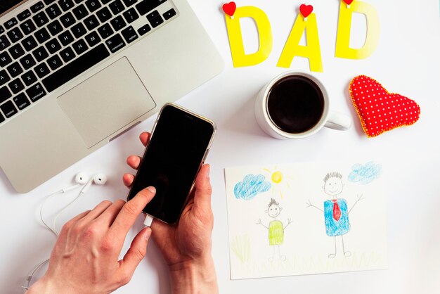 Composición para el día del padre con portátil y smartphone