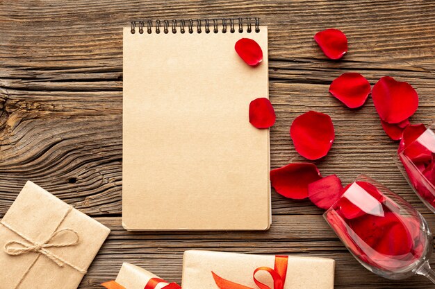 Composición del día de San Valentín con bloc de notas vacío y pétalos