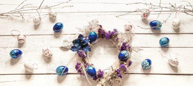 Composición elegante con una corona de Pascua y huevos de tendencia azul.