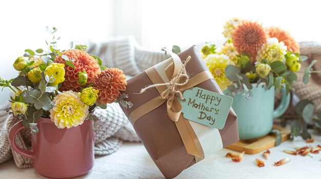 Composición festiva para el día de la madre con caja de regalo y flores.