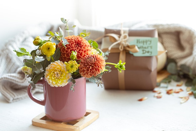 Composición festiva para el día de la madre con caja de regalo y flores.