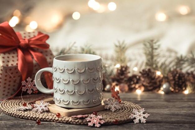 Composición festiva con taza blanca y caja de regalo.