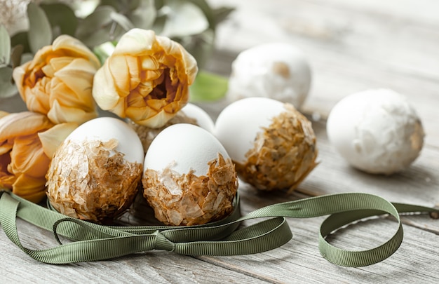 Composición festiva para las vacaciones de Pascua con huevos decorados y flores frescas.