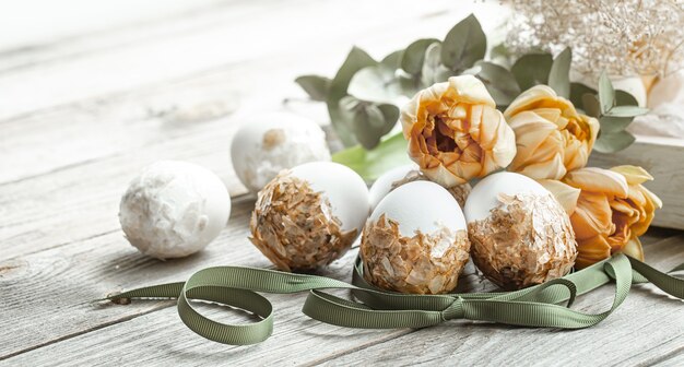 Composición festiva para las vacaciones de Pascua con huevos decorados y flores frescas.