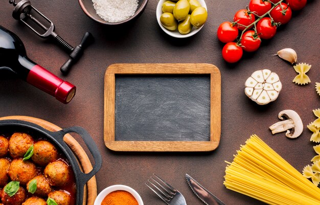 Composición flat lay de comida italiana con plantilla de pizarra