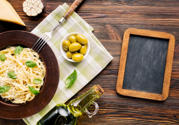 Composición flat lay de comida italiana con plantilla de pizarra