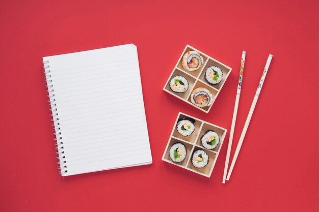 Composición flat lay de sushi con plantilla de libreta