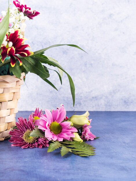 Composición de flores coloridas y plantas tropicales en cesta.