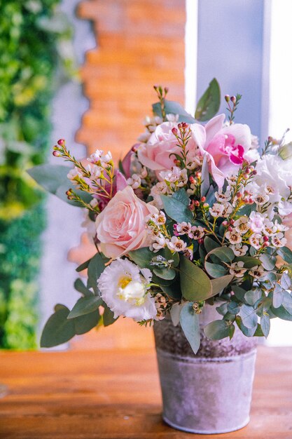 Composición de flores en el cubo rosas orquídeas litianthus vista lateral