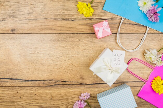 Composición de flores frescas cerca de la etiqueta en las cajas actuales cerca de paquetes de papel