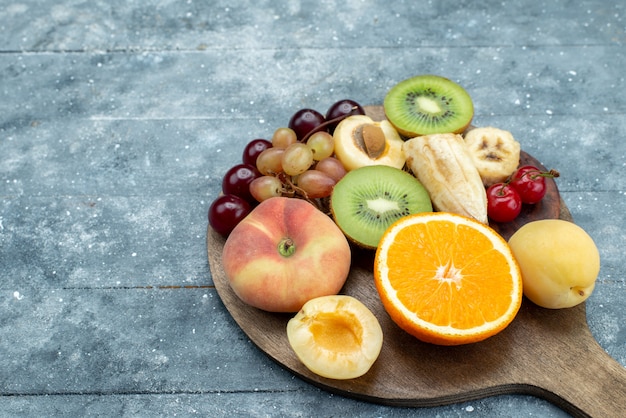 Foto gratuita composición de fruta vista frontal en rodajas y entera en gris