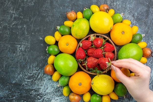 Composición de frutas frescas de vista superior con fresas rojas sobre fondo gris