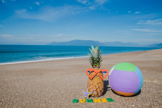 Composición de frutas y pelota en la playa