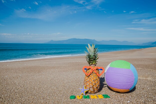 Composición de frutas y pelota en la playa