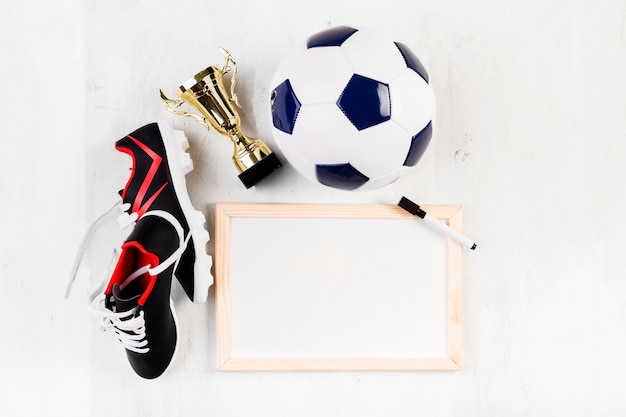 Composición de fútbol con pizarra blanca y zapatos