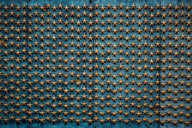 Composición genial de una pared azul con muchas figuras de estrellas doradas