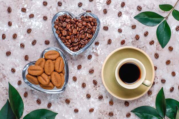 Composición con granos de café tostado y galletas con forma de granos de café.