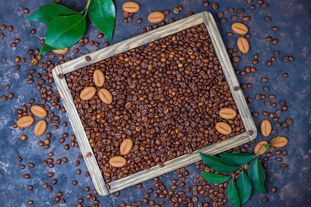 Foto gratuita composición con granos de café tostados y galletas con forma de grano de café sobre una superficie de color marrón oscuro