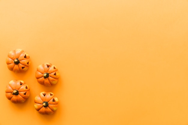 Foto gratuita composición de halloween con cuatro calabazas y espacio