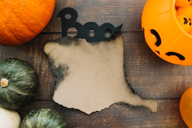 Foto gratuita composición de halloween con papel quemado y signo boo