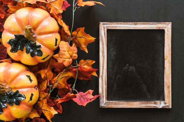 Foto gratuita composición de halloween con pizarra y hojas de otoño