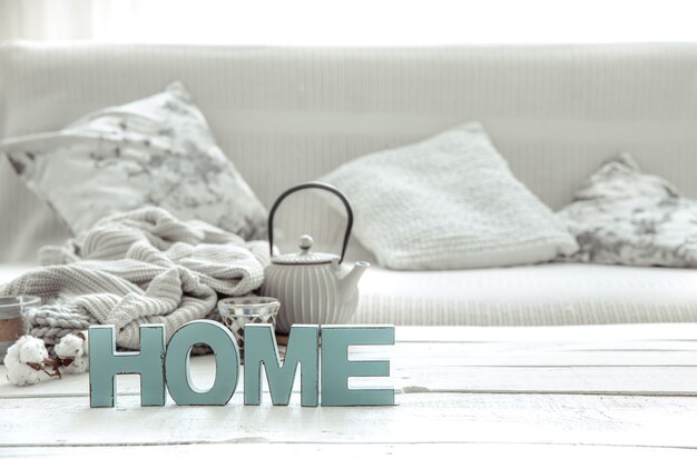 Composición hogareña acogedora con tetera, artículos de punto y detalles decorativos escandinavos. El concepto de confort hogareño y estilo moderno.