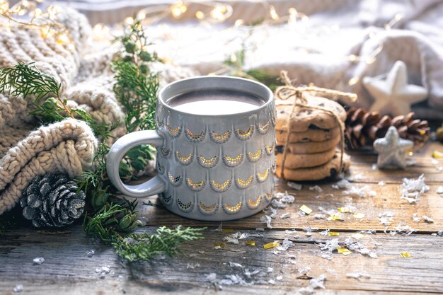 Composición de invierno con una taza de galletas de cacao y detalles decorativos