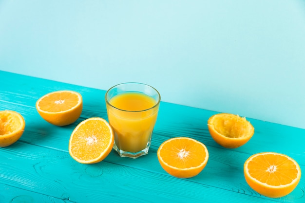 Composición del jugo de naranja fresco en la mesa azul