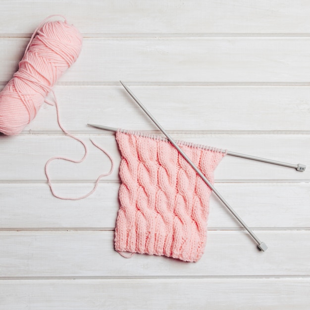 Composición de lana rosa con agujas