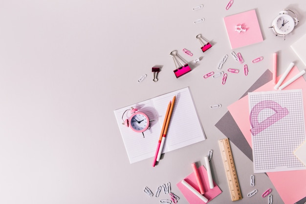 Composición de material de oficina de niña en tonos rosados y blancos.