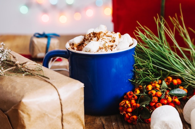 Composición de navidad con café al lado de muérdago y caja de regalo