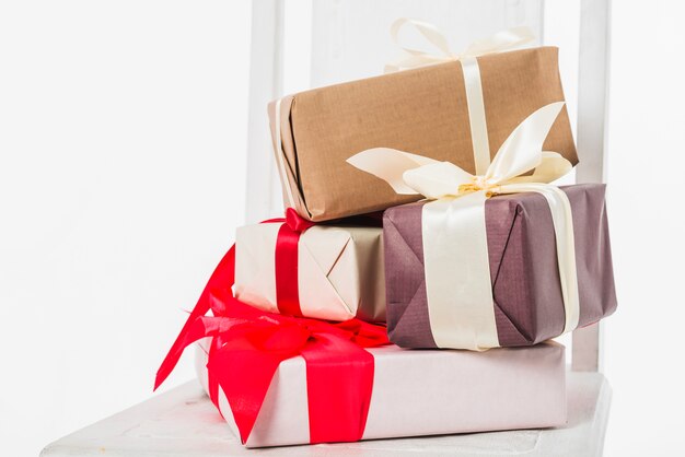 Composición navideña de cajas de regalo en silla.